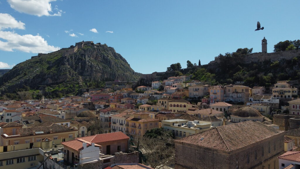 Scenic view of a historic hillside town with terracotta rooftops and a clear blue sky.